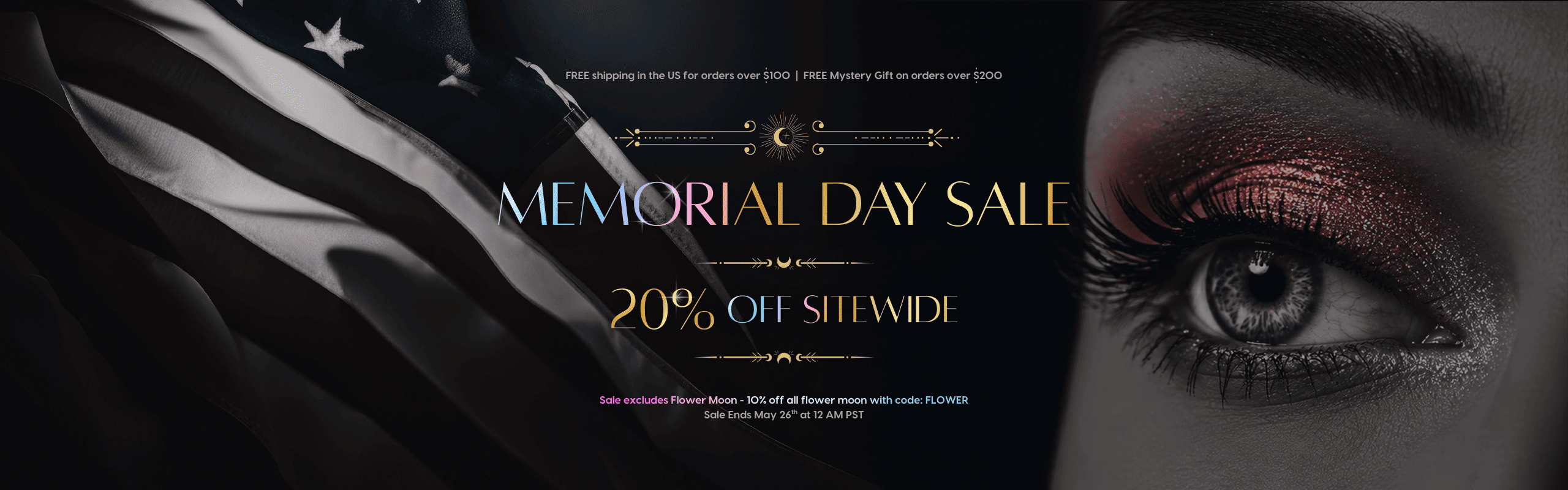 Memorial Day Sale banner featuring a dramatic dark background with a black-and-white American flag on the left and a close-up of an eye with bold red glittery makeup on the right. Text reads: FREE shipping in the US for orders over $100 | FREE Mystery gift on orders over $200. Memorial Day Sale — 20% off sitewide. Sale excludes Flower Moon — 10% off all Flower Moon with code: FLOWER. Sale ends May 26th at 12 AM PST.